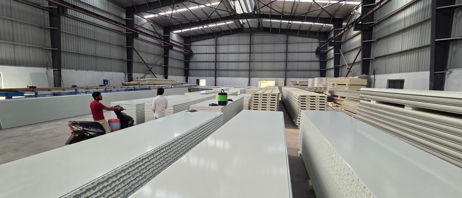 Finished white PUF panels stacked inside the Bisbee Technology factory warehouse