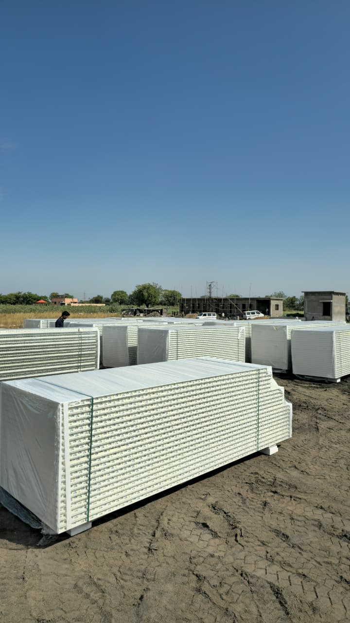 Wide shot of outdoor staging yard with multiple wrapped panel stacks ready for shipment