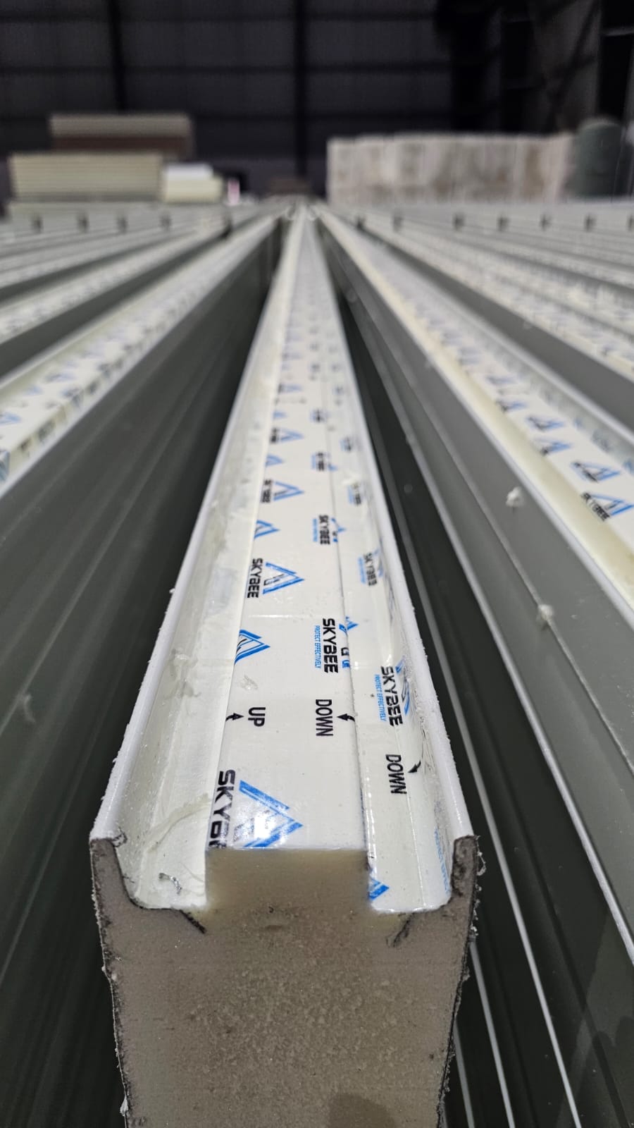 Close-up of Skybee branded insulated sandwich panel interlocking joint and core